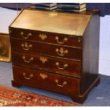 A Georgian oak writing bureau, with hinged writing flap enclosing fitted drawers and pigeon holes,