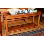 A modern oak two tier coffee table, with glazed top, raised on cylinder columns,