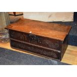 An 18th century and later oak blanket chest, with hinged top above carved foliate front,