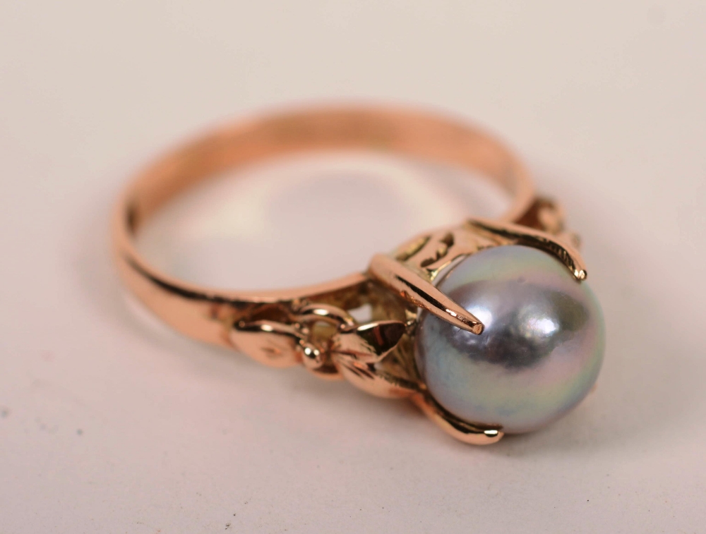 A 14ct gold grey pearl ring, the large central pearl within claw setting,