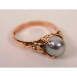 A 14ct gold grey pearl ring, the large central pearl within claw setting,