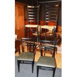 A pair of Italian retro ebonised ladder back chairs, with rush seats,