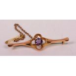 A 9ct gold and amethyst brooch, the central round cut amethyst set in flowerhead claw formation, 2.