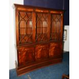 A Regency style mahogany bookcase, on cupboard base, of curved form,