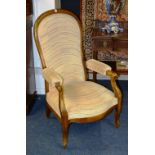 A Victorian mahogany library open armchair, with cushioned arm rests ending in scroll terminals,