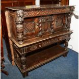 A Jacobean style oak court cupboard, with central carved panel flanked by foliate carved door,