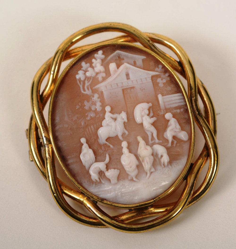 A yellow metal cameo brooch, the oval cameo depicting domestic rural scene with figures and dogs and