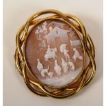 A yellow metal cameo brooch, the oval cameo depicting domestic rural scene with figures and dogs and