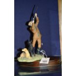 A Border Fine Arts figure of a man shooting, with gundogs, raised on stand,