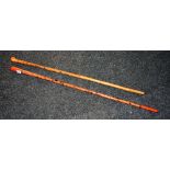 Two walking canes, one carved with animals, the other red lacquered,