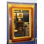 A rosewood wall mirror, decorated with gilded border and appliques,