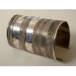 A large silver bangle / cuff, of Eastern design, tapering in design to fit wrist, stamped 925, 7toz,