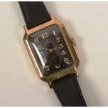 An early 20th century 9ct gold Rolex wristwatch, the black enamel face with gold Arabic numerals and