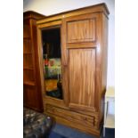 A Victorian style mahogany wardrobe, with moulded cornice above mirrored panel and panelled door,
