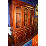 A Victorian style mahogany bookcase, on chiffonier base, with doors enclosing shelved interior,