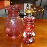 A late 19th century cranberry glass oil lamp, with shade,