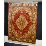 A Kum motif carpet/wall hanging, the cream central medallion over red ground, with floral design,