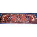 A vintage Persian Brojerd runner, with triple medallion over red ground with bird and leaf design,