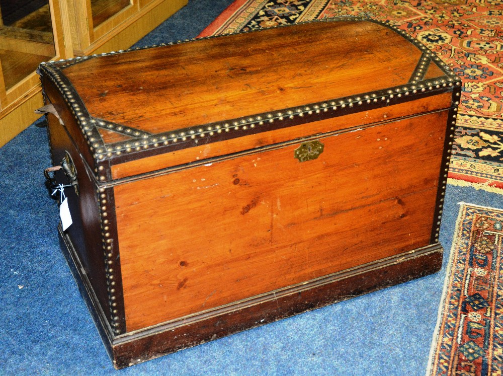 A Victorian pine domed trunk, with studded hinged lid enclosing fitted candle box and drawers,