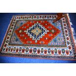 A Turkish rug, the central star medallion over red ground with blue spandrels and triple border,