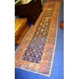 An antique Caucasian runner, with allover diamond and rosette design, over blue ground and triple