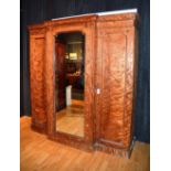 A Victorian breakfront wardrobe, with moulded cornice above mirrored door, flanked by panelled door,