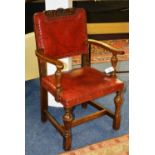 A Jacobean style oak open armchair, with crested and scroll decoration to top,