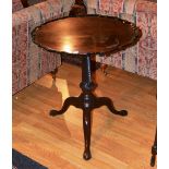 A Georgian mahogany pedestal table, the pie crust tilt top raised on fluted spiral turned column,