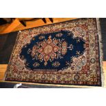 A Persian rug, the central rosette over blue ground with spandrels and triple floral border, signed,