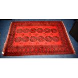 A fine Afghan carpet, with two rows of six medallions over red ground and borders,