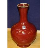 A Chinese sang de bouf pottery vase, with trumpet shaped neck, glazed in red, 36cm high CONDITION