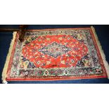 A Persian rug, the central medallion over red ground, with floral decoration, spandrels and border,