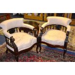 A pair of Victorian style drawing room armchairs, of tub shape, upholstered in cream floral fabric,