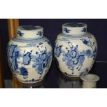 A pair of Chinese ginger jars and covers, with blue decorated figures in foliage, on white ground,