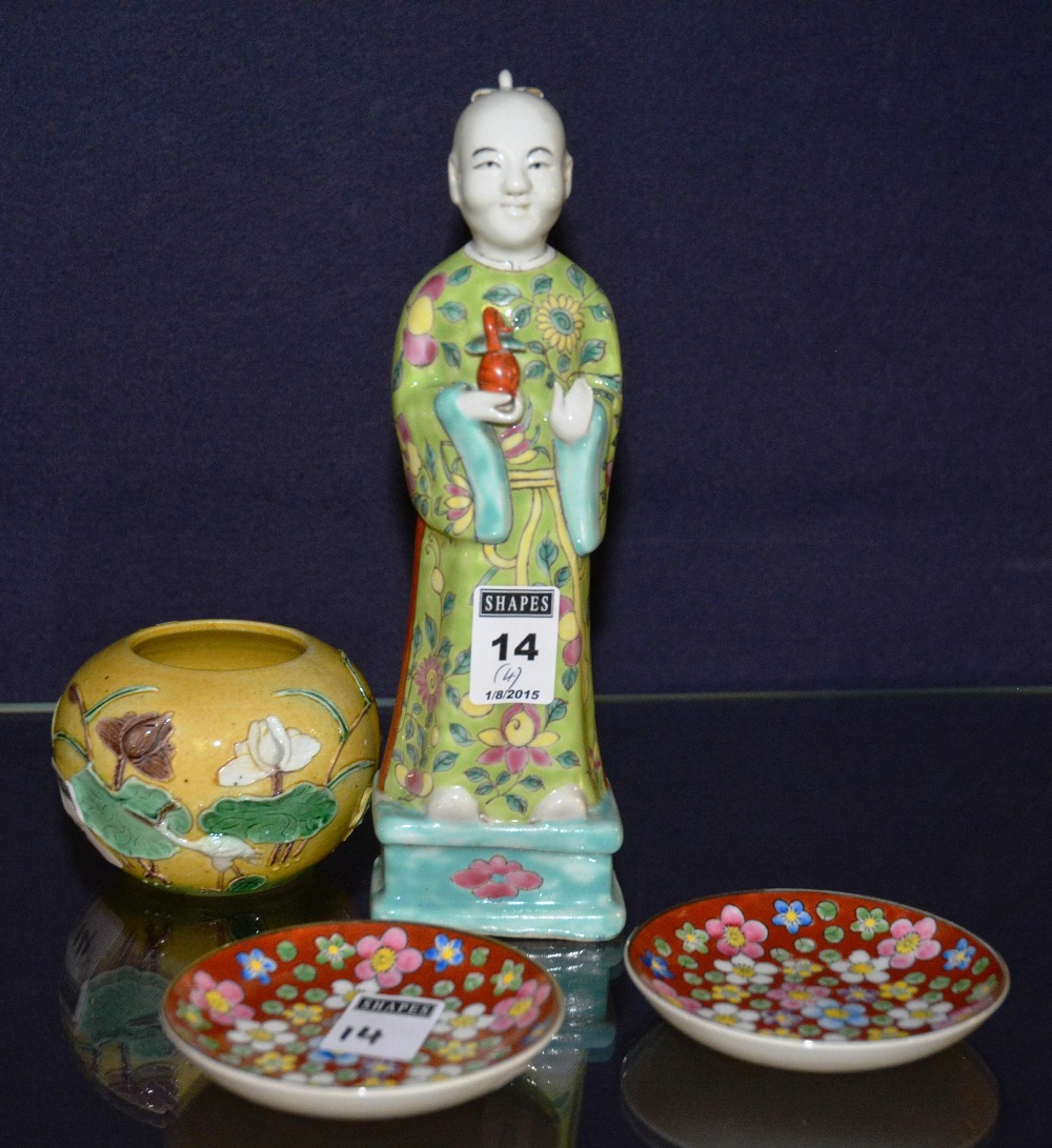 A Chinese glazed pottery figure of a monk holding vase, in green glazed floral gown, 23cm high,