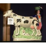 A 19th century Staffordshire cow creamer, modelled with glazed female figure and recumbent calf,