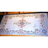 An Indian rug, the central floral rosette over cream ground and floral border,