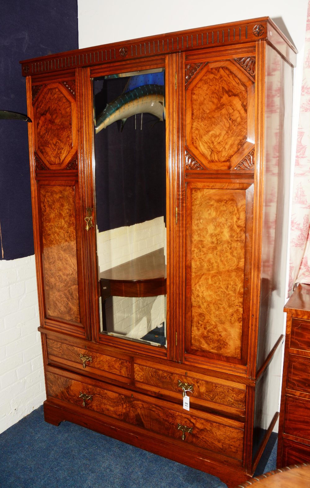 A late Victorian walnut wardrobe, with moulded cornice above central glazed door,