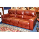 A modern red leather three seater settee by Violino,