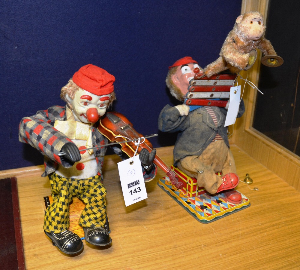 Two vintage tin plate battery operated clown figures, one playing a fiddle,