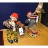 Two vintage tin plate battery operated clown figures, one playing a fiddle,