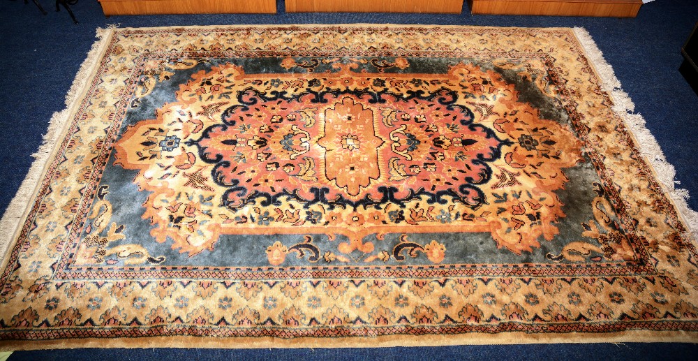 An Indian rug, the central peach medallion over cream and blue ground,