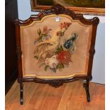 A Victorian mahogany firescreen, with embroidered panel depicting bird in foliage, 85cm high x