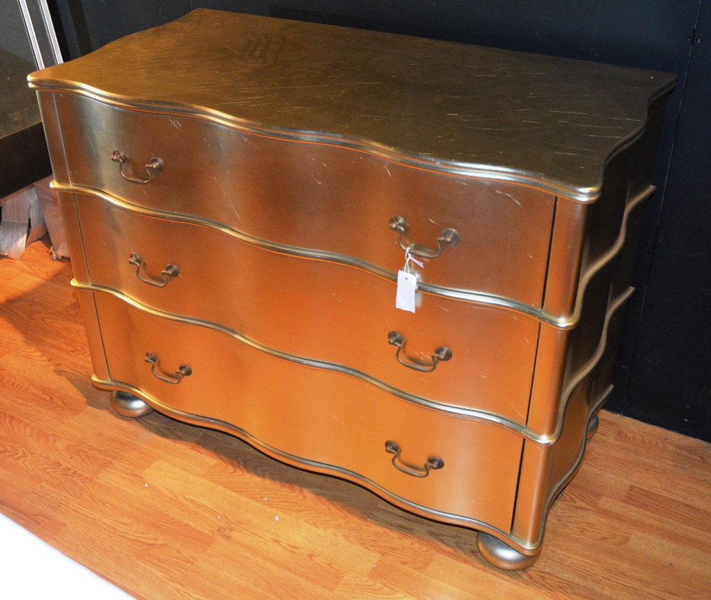 A contemporary gilt finished serpentine desk, the reeded top over three long drawers,