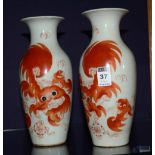 A pair of Chinese shishi pottery vases, decorated with orange glaze on white ground,