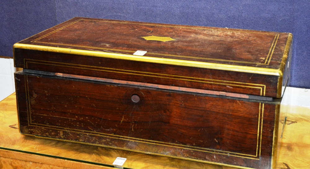 A Victorian rosewood and brass bound lap desk, with hinged writing slope and integral drawers,