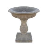 Estate sculpted stone bird bath of circular form, with reeded body, raised on an acanthus leaf