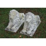 Pair of early twentieth-century reconstituted stone recumbent lions 82 cm. long; 55 cm.