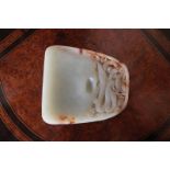 CHINESE QING PERIOD CELADON JADE INK STONE with russet inclusions, decorated with raised dragon