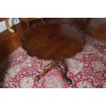 GEORGE III STYLE MAHOGANY SNAP-TOP SILVER TABLE the circular serpentine top with a pie-crust border,